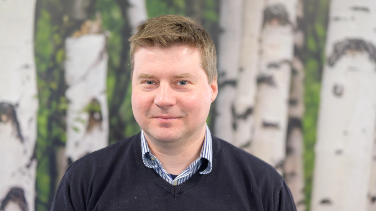 En man som står framför en målning av träd