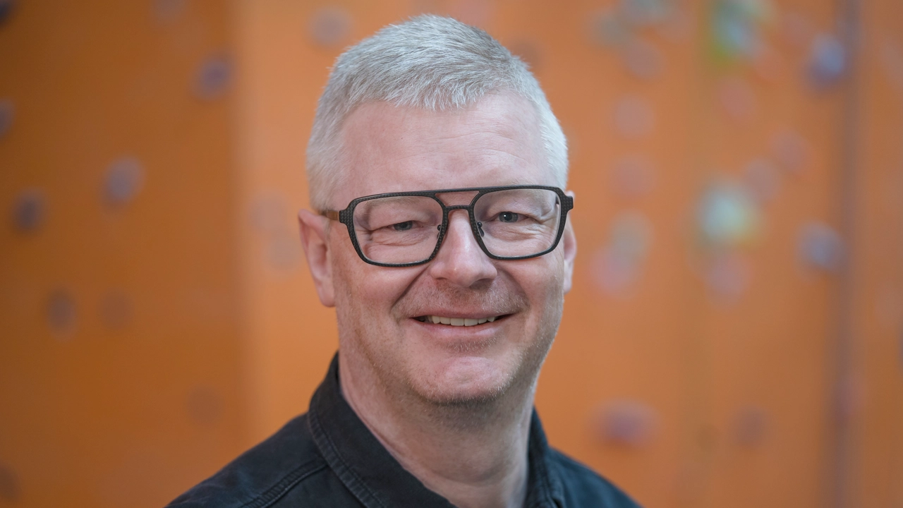 Man tittar in i kameran och ler.