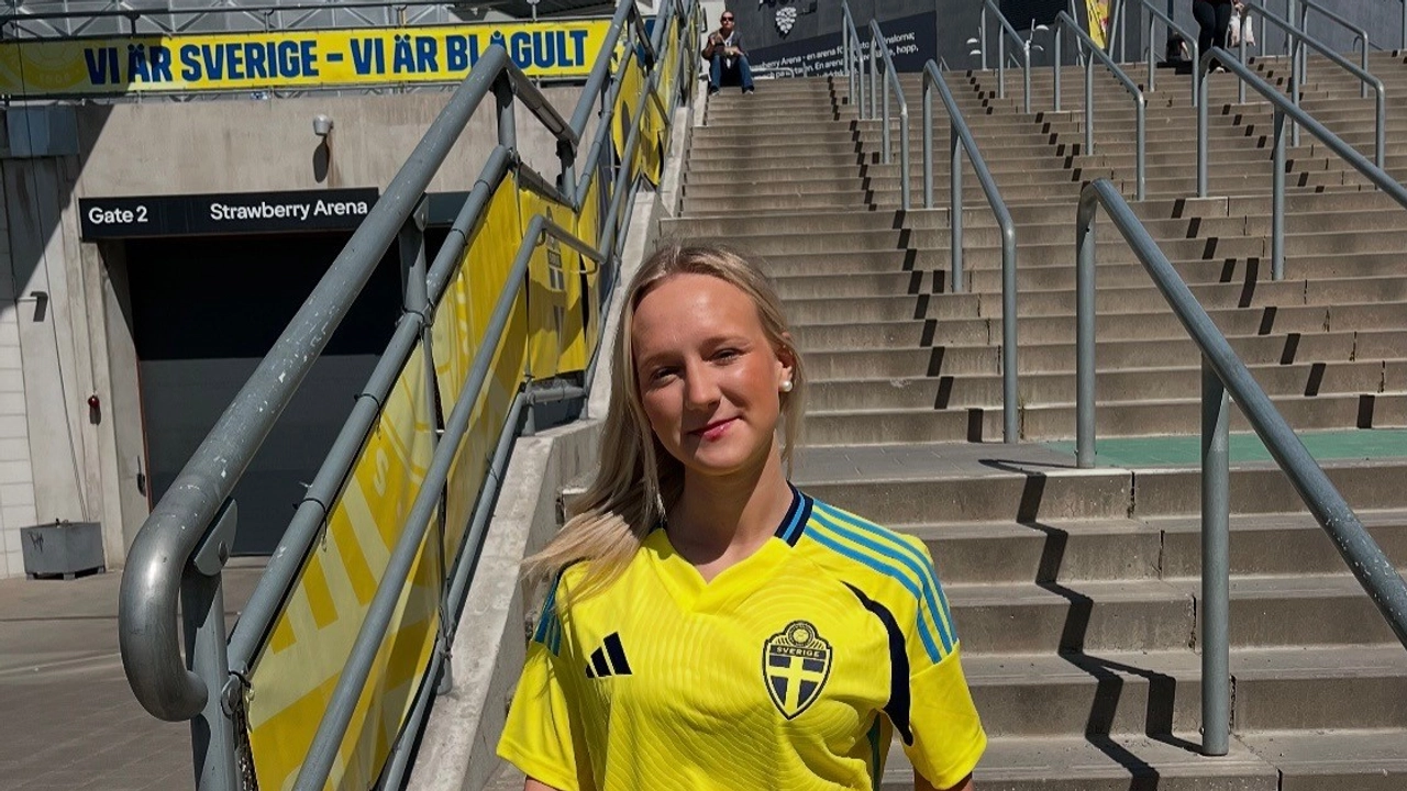 En kvinna i landslagströja står på en trappa.