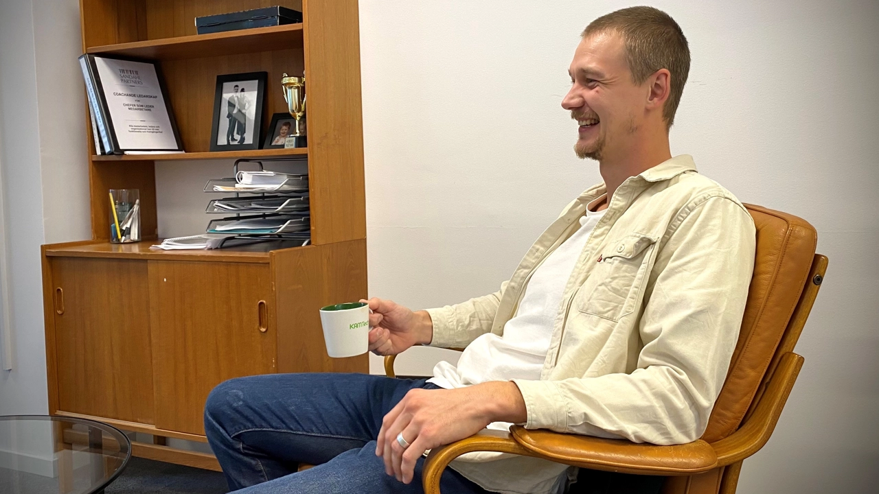 Bild på Kalle Almstedt sittande i en fåtölj med en kaffekopp i handen.