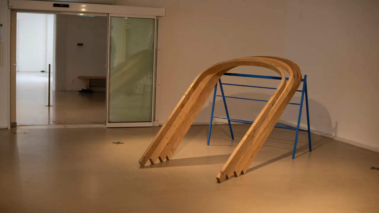 En U-formad träkonstruktion lutad mot en metallställning.