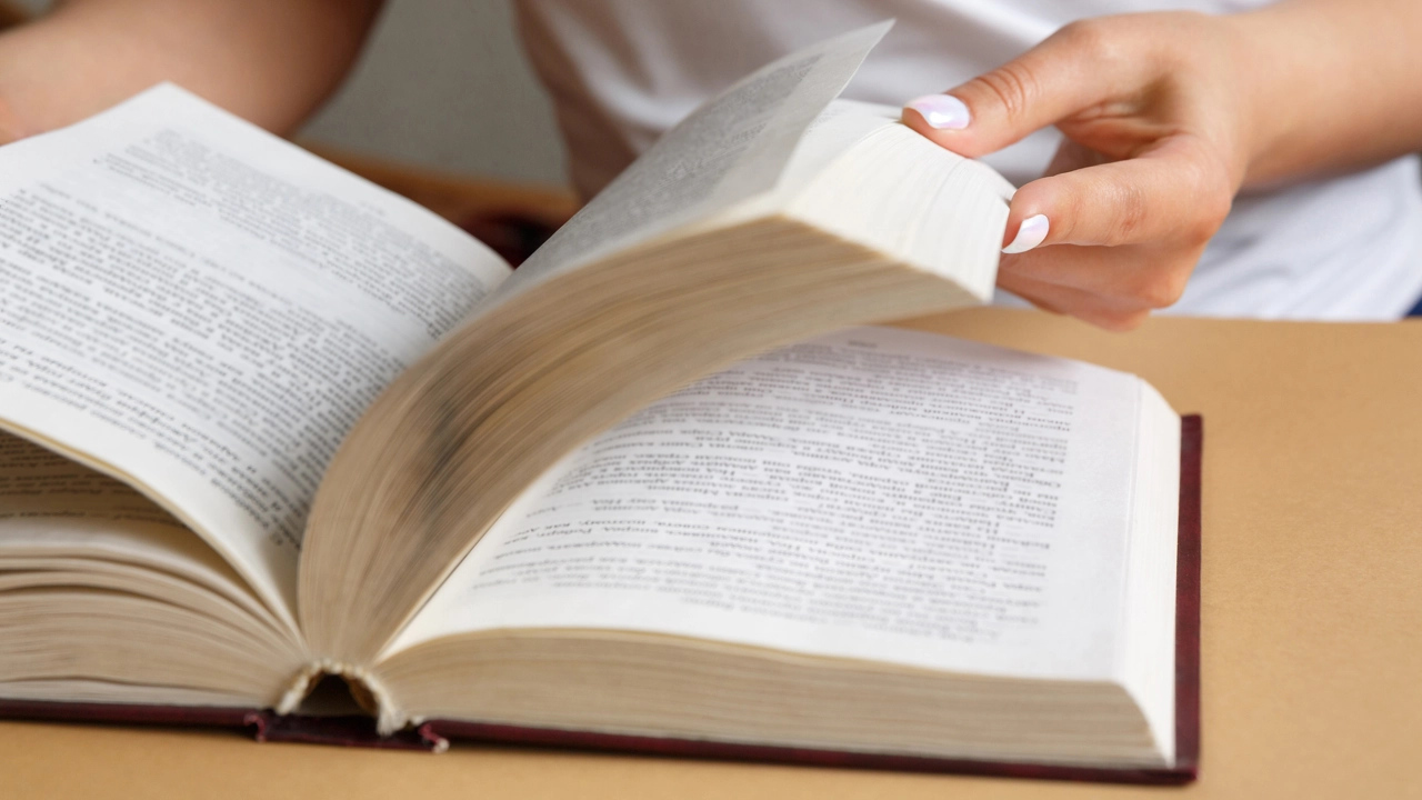 Närbild på händer som bläddrar i en bok.