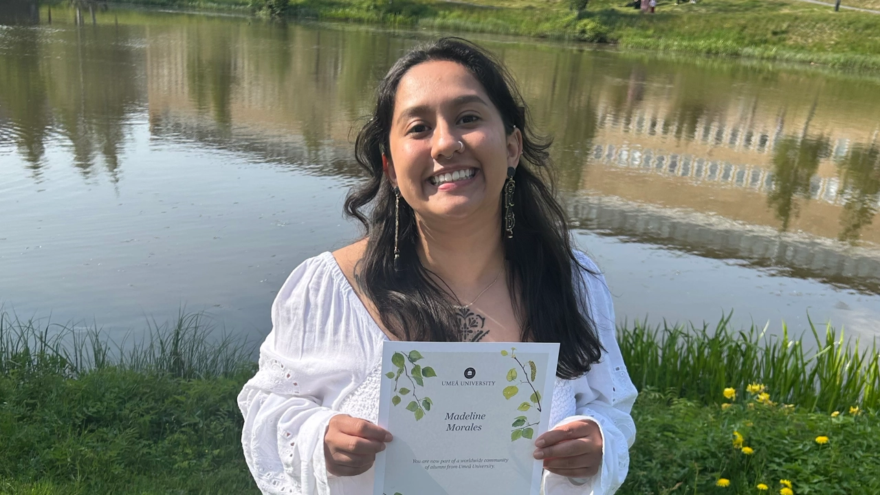 New graduate by the campus pond at Umeå University 