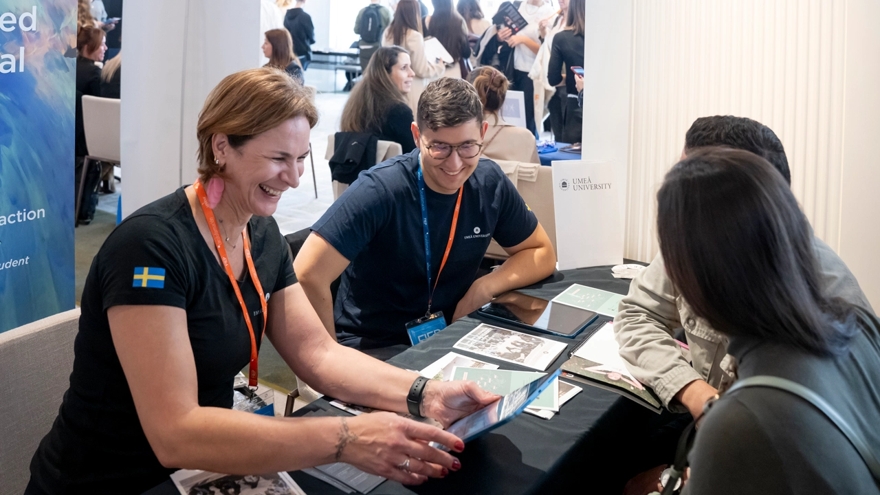 University staff meet prospective students at a fair.
