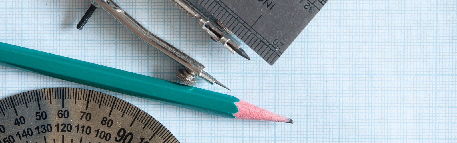 En sax, en linjal och en blyertspenna på ett papper.