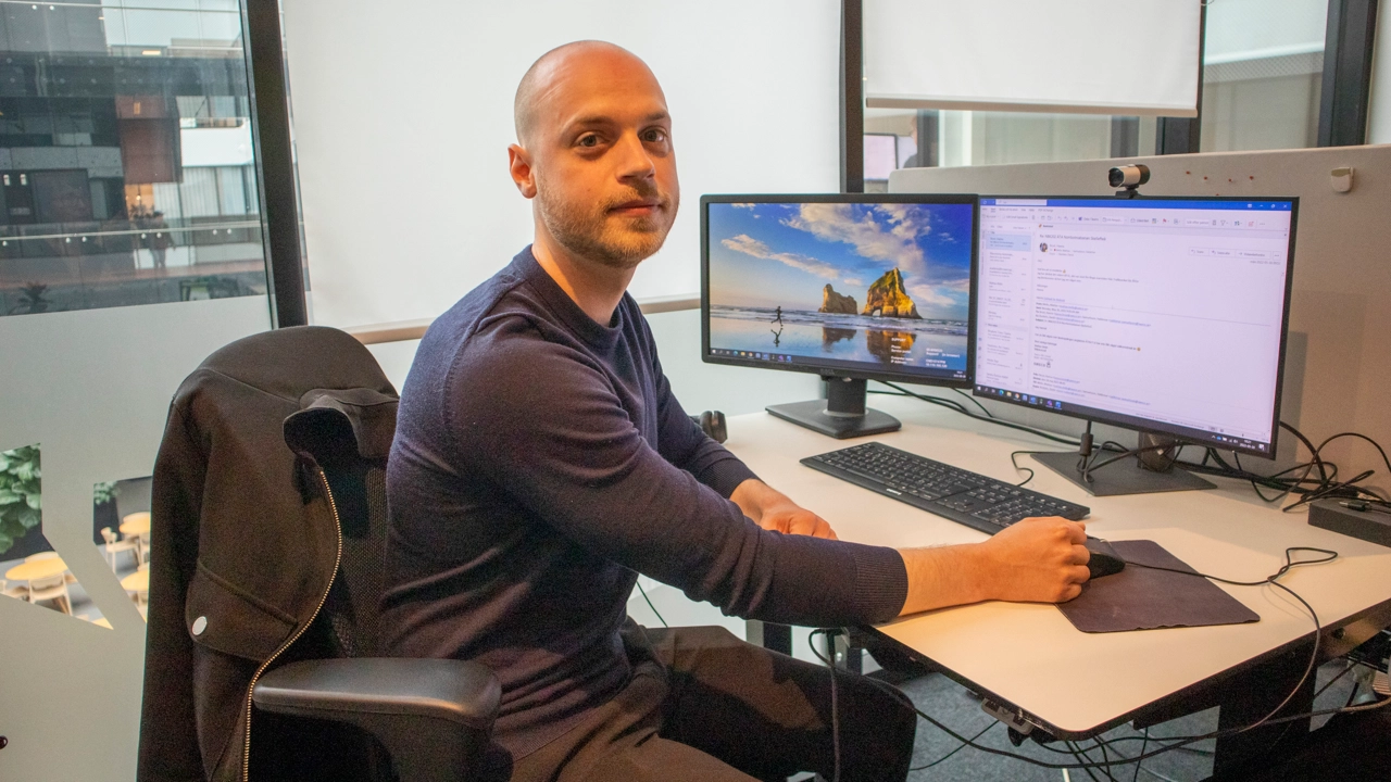 Bild på Mattias Melin sittande vid skrivbord med dator