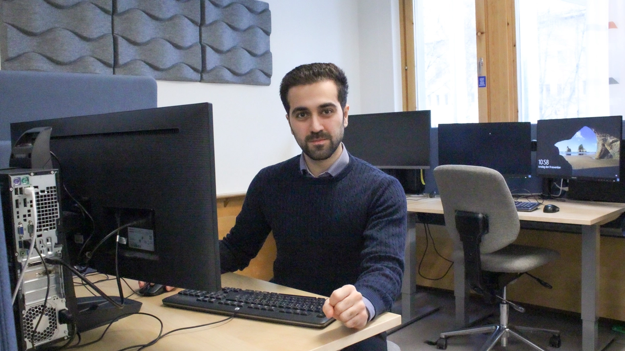 Bild på Mert Karkan sittande vid dator i datorsal.