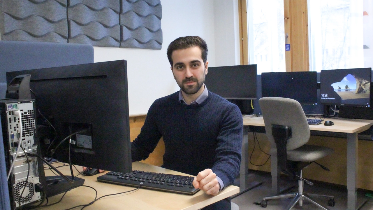 Bild på Mert Karkan sittande vid dator i datasal