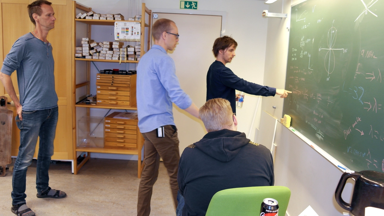 Bild på lärare och studenter vid tavlan i elektroniklabbet