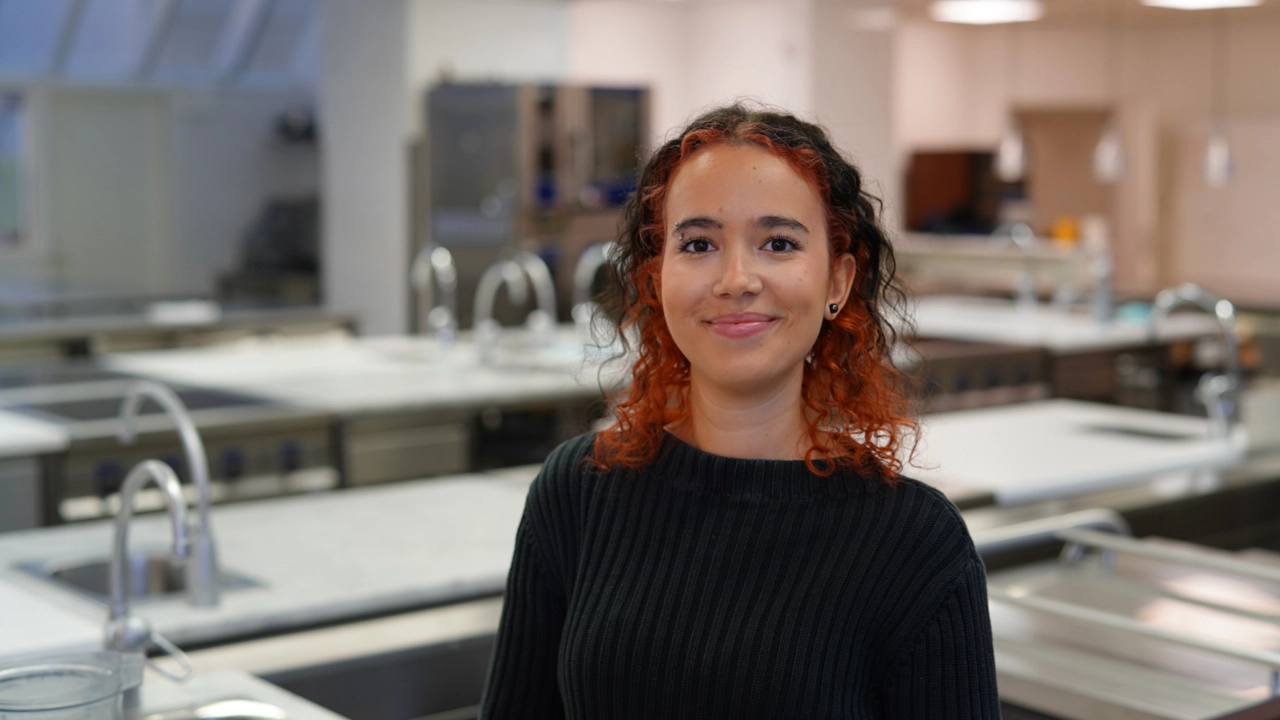 Porträtt av gastronomistudent i köksmiljö. 