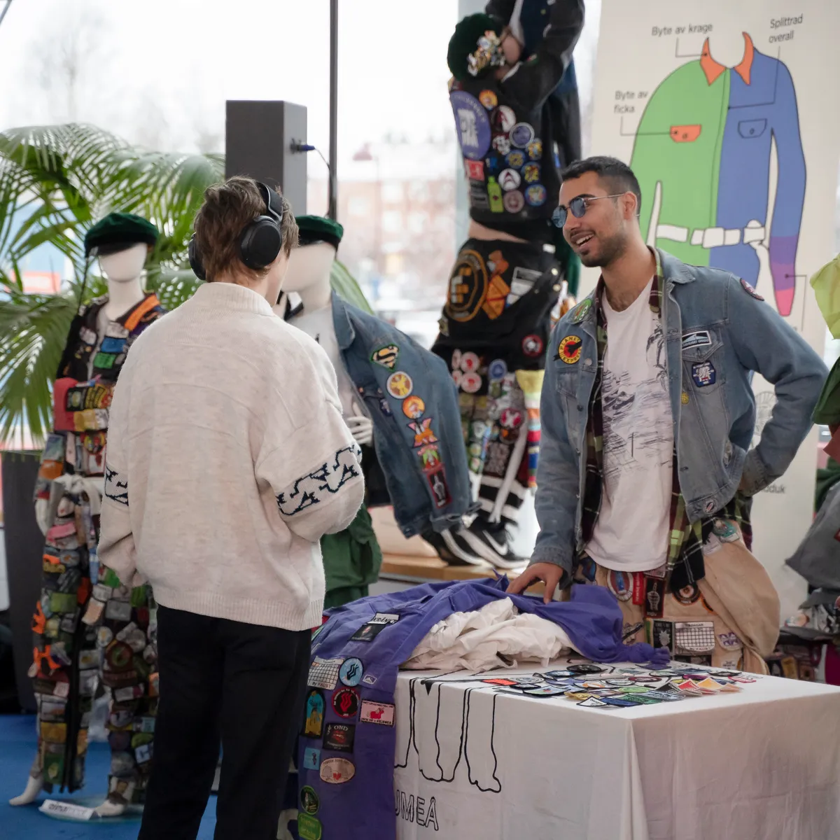 Student berättar om overaller på mässa.