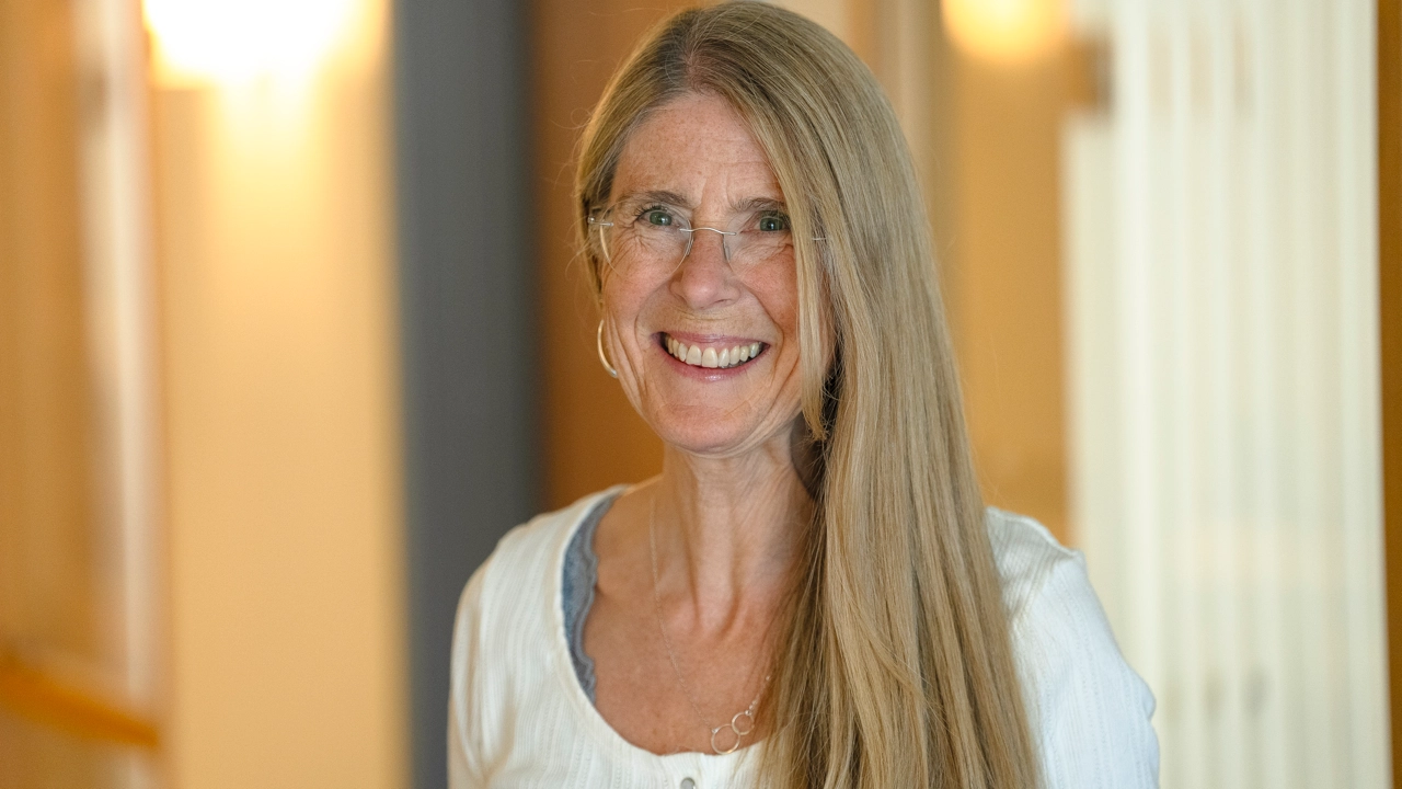 Kvinna ler och tittar in i kameran.