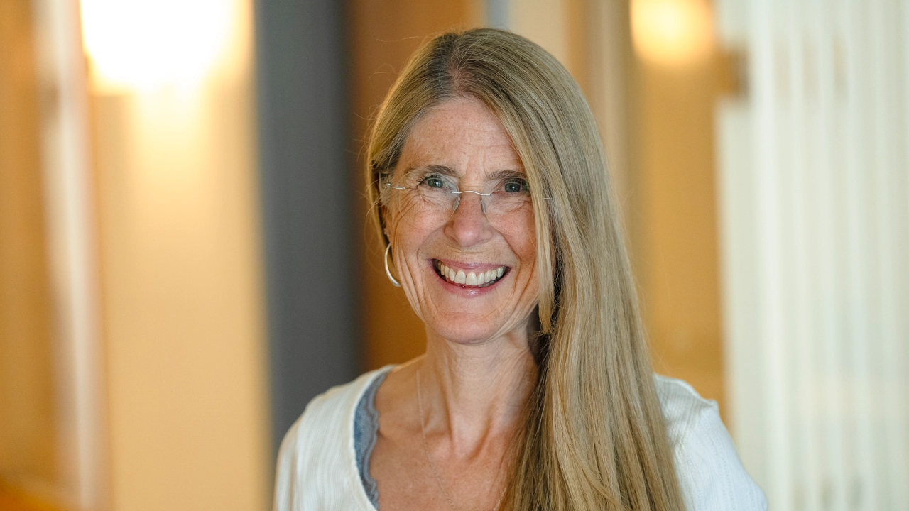 Kvinna ler och tittar in i kameran.