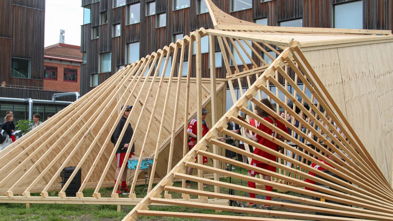 1x1 scale pavilion outside Umeå School of Architecture, students playing on drums inside