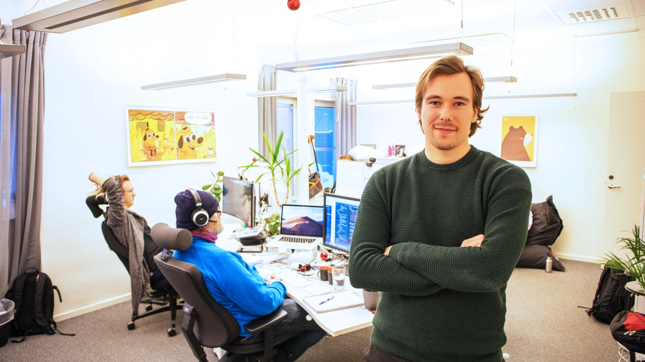 Bild på Peter Bjuhr, stående i kontorslandskapet på Codemill, medarbetare vid skrivbord i bakgrunden