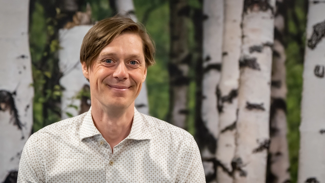 En man som står framför en målning av träd