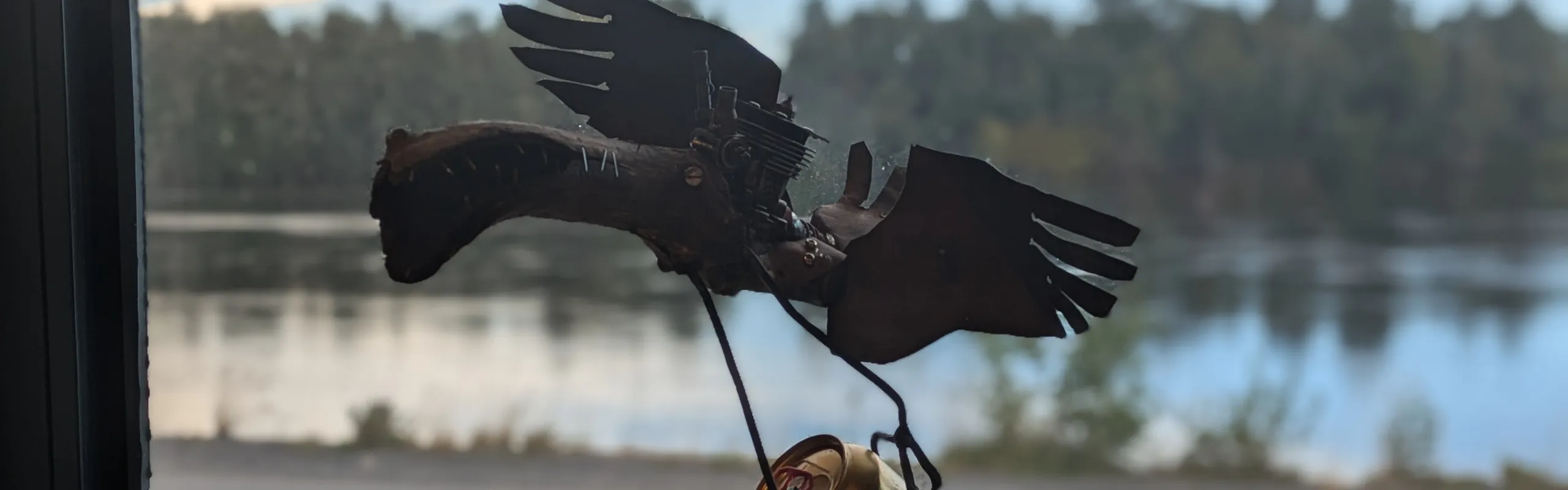 Skulptur i plåt av fågel med ölburk