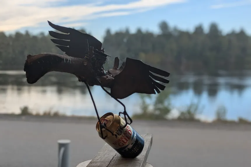 Skulptur i plåt av fågel med ölburk