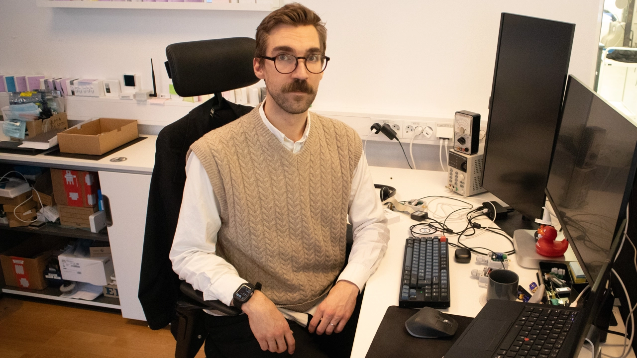 Bild på Pontus Hedenström sittande vid skrivbordet på sin arbetsplats