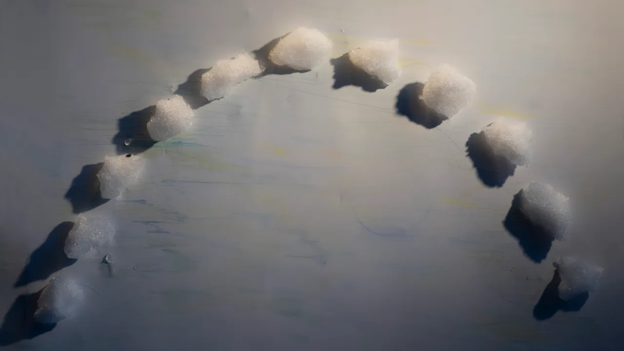 Snöklumpar i halvcirkel på vitt papper