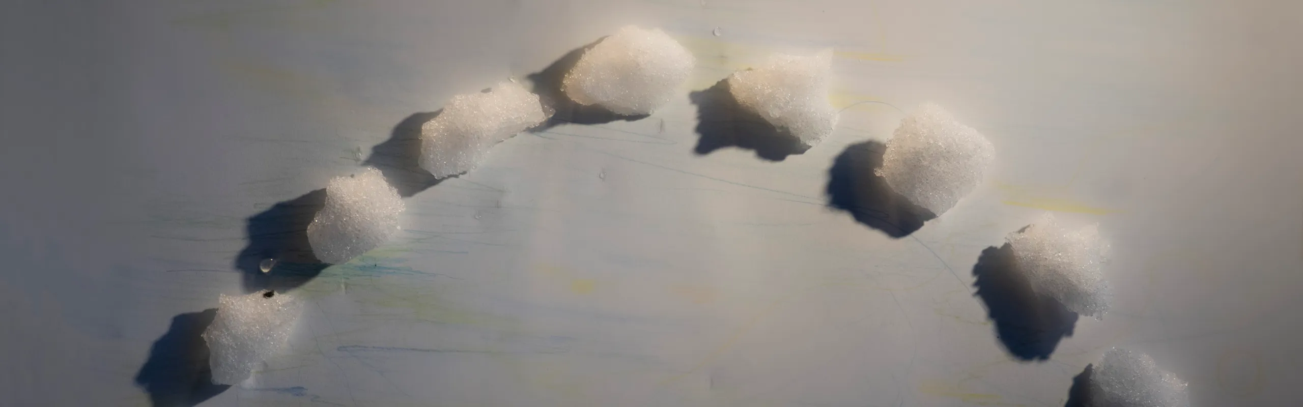 Snöklumpar i halvcirkel på vitt papper