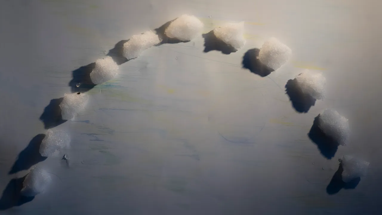 Snöklumpar i halvcirkel på vitt papper