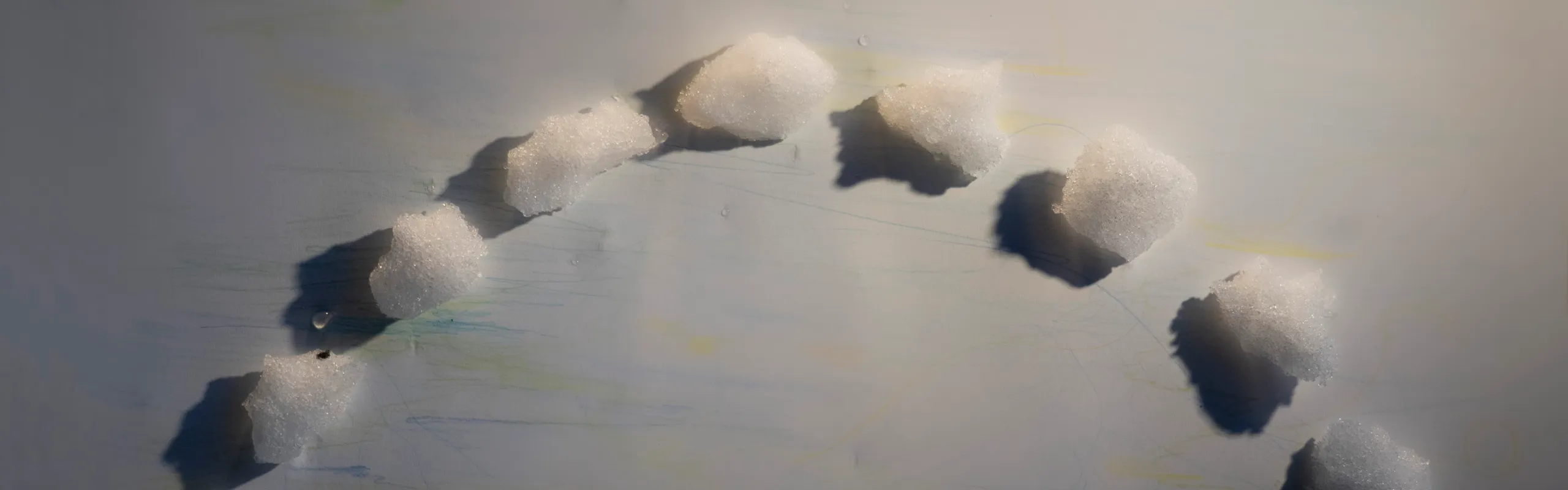 Snöklumpar i halvcirkel på vitt papper