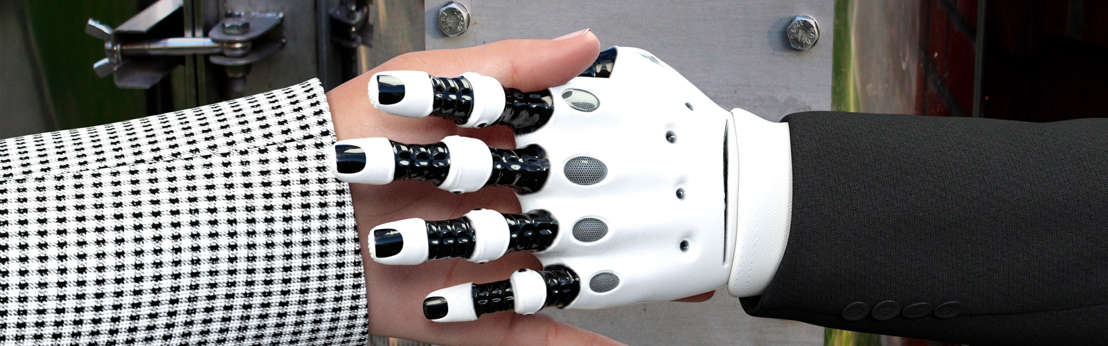 Närbild på robothand skakar hand med en människa.
