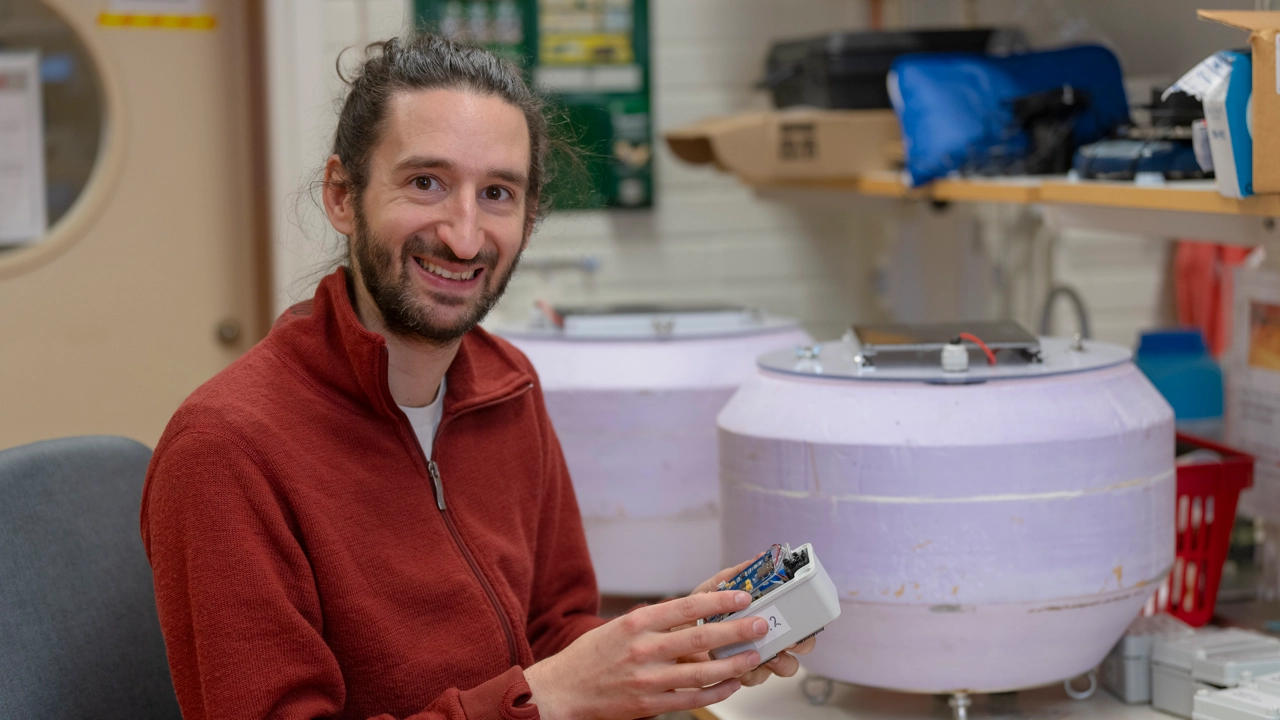 Man ler mot kameran i labbmiljö. 