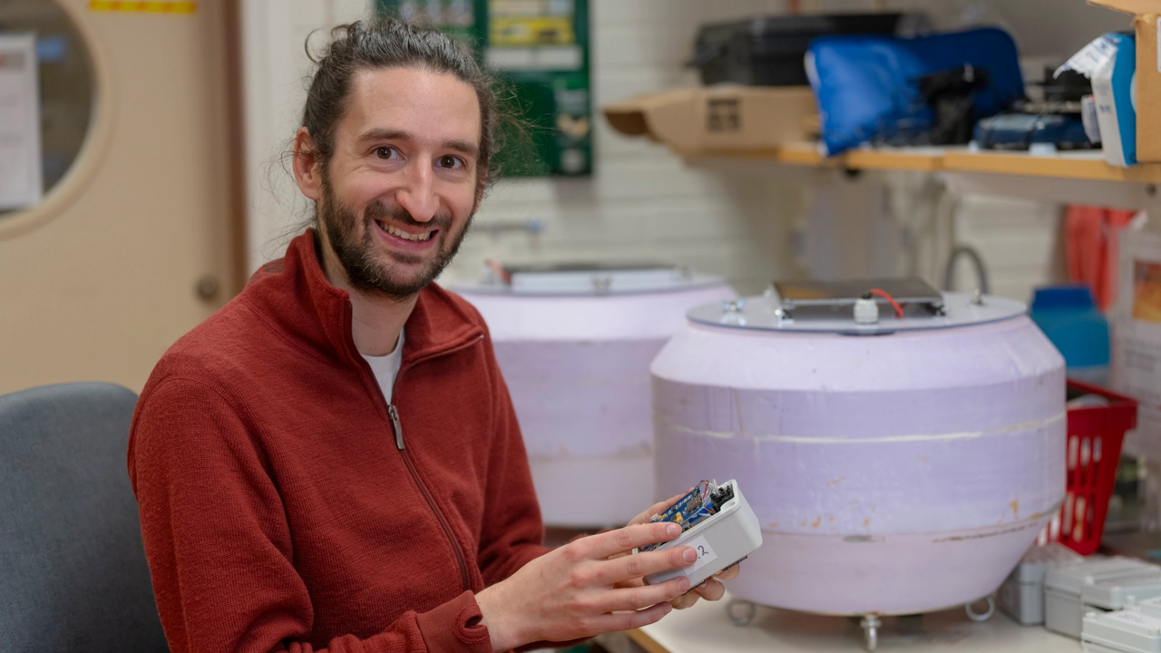 A man smiling for the camera in a research lab.