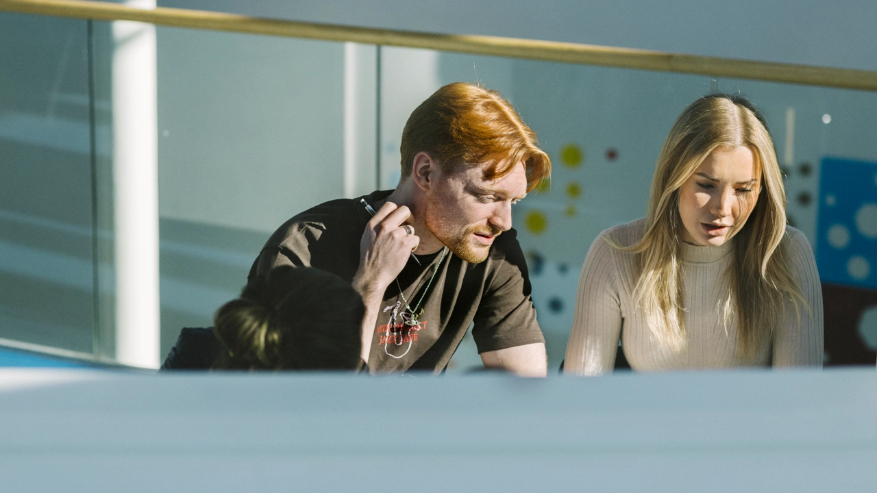 Två studenter har hittat en solig plats att jobba med sitt grupparbete på.