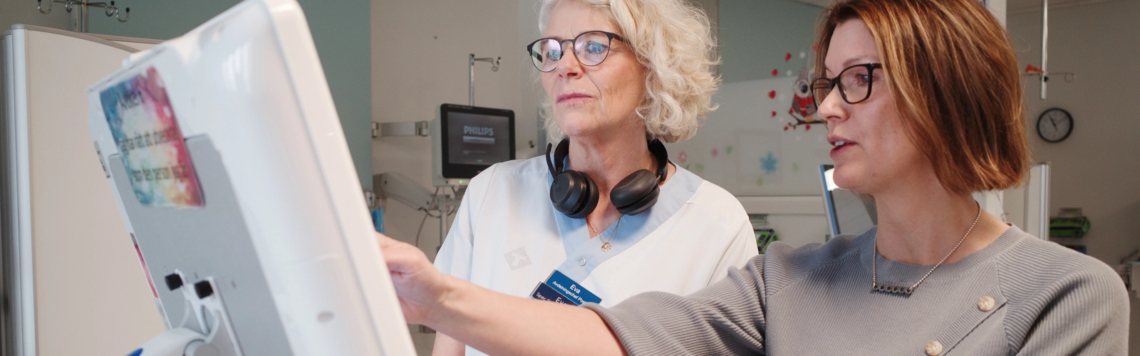 Två kvinnor framför en datorskärm.