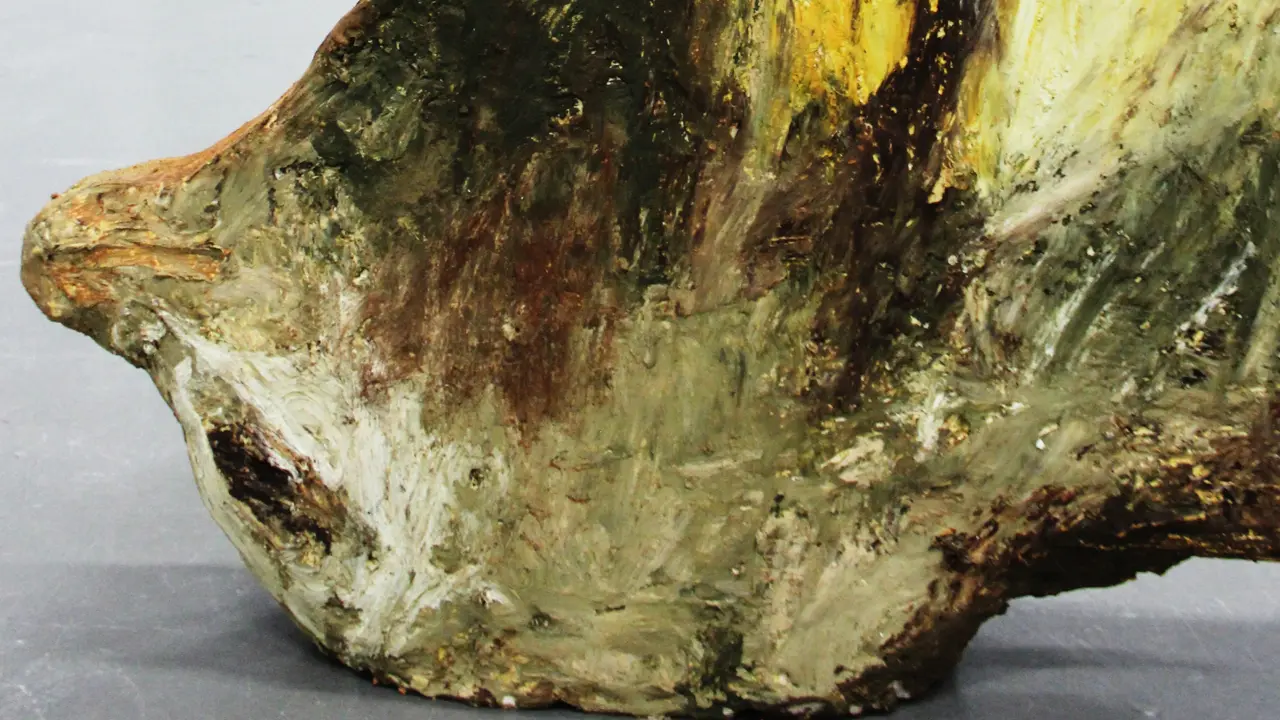 Abstract sculpture in the colours green, brown, beige and yellow.