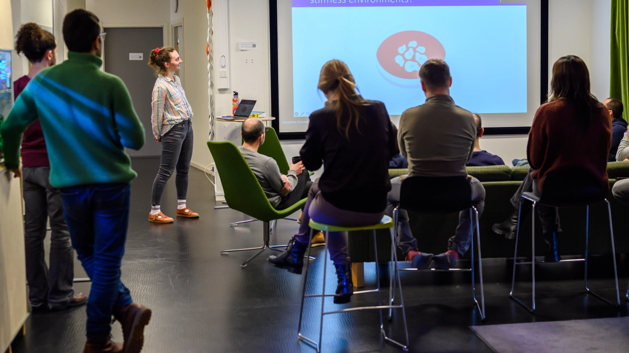A group of people standing in front of a projector screen