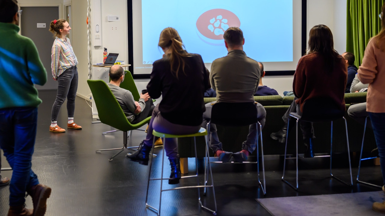 A group of people standing in front of a projector screen