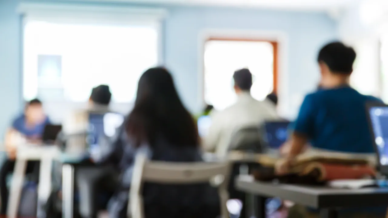 Blurry people sitting in a classroom listening to a lecture.