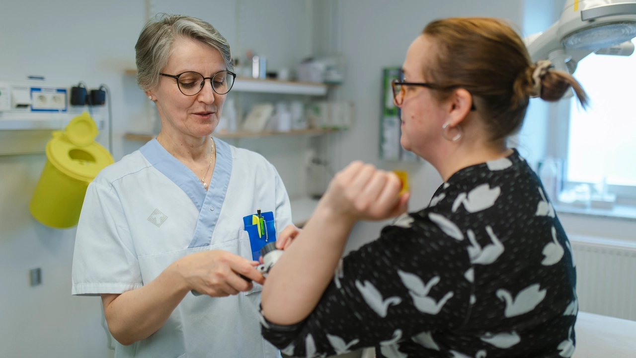 En läkare undersöker en patients armbåge.