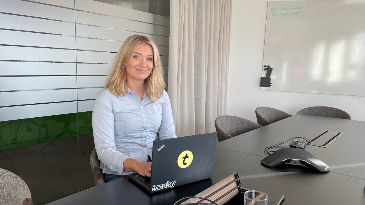 Bild på Signe Grönberg sittande vid ett konferensbord med laptop framför sig.