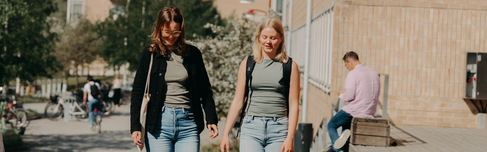 Två kvinnor promenerar på campus.