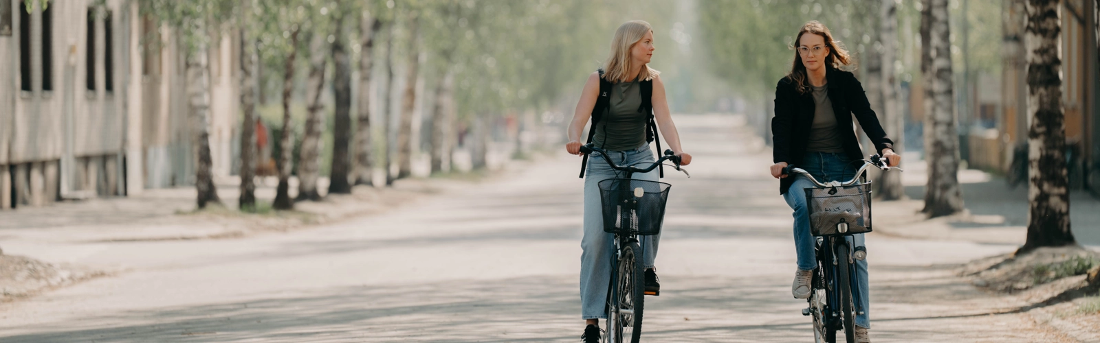 Två kvinnor cyklar bredvid varandra.