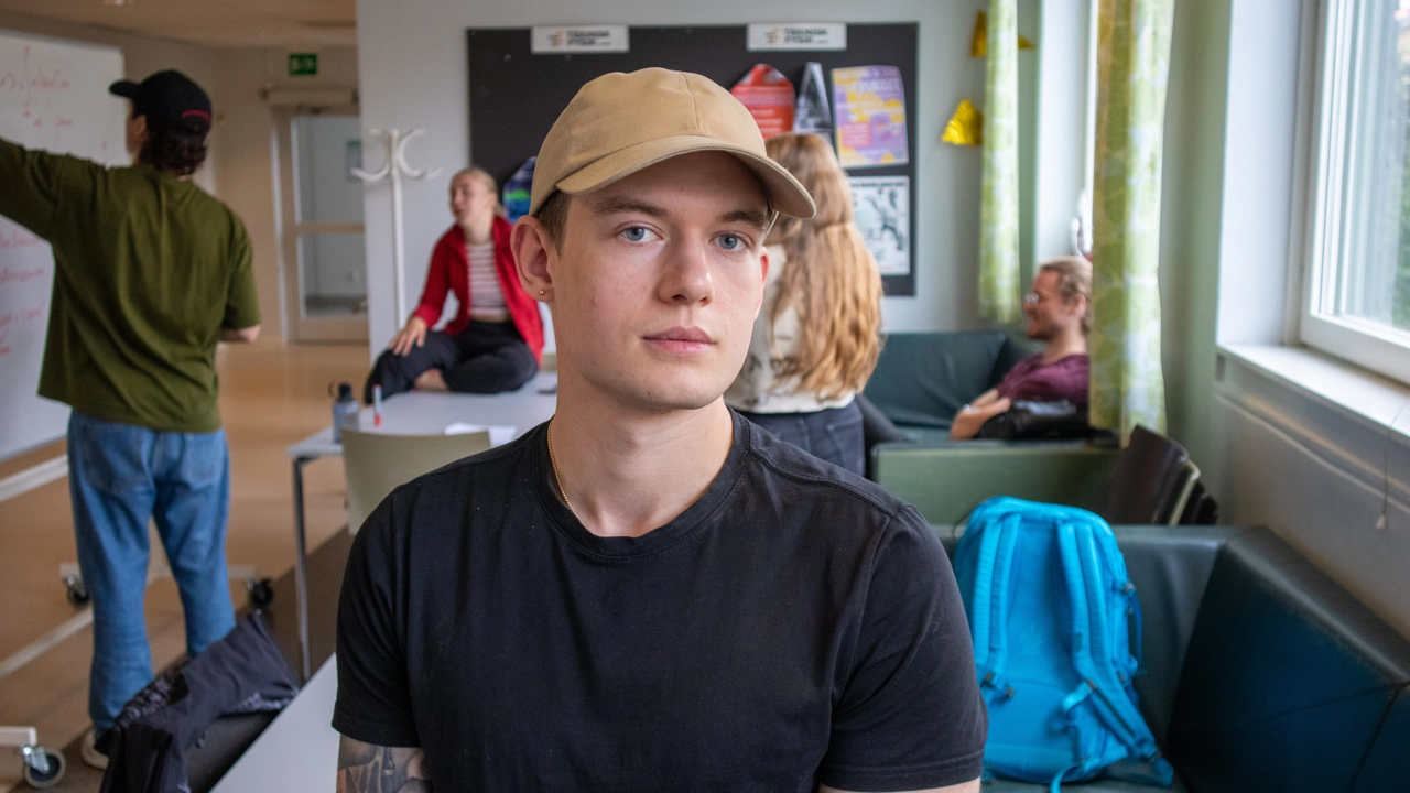 Bild på Theodor Ringius, i bakgrunden studenter i teknisk fysiks korridor i Naturvetarhuset