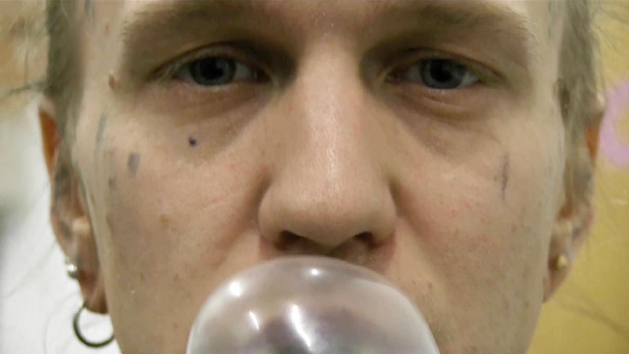 Person blåser bubbla med tuggummi