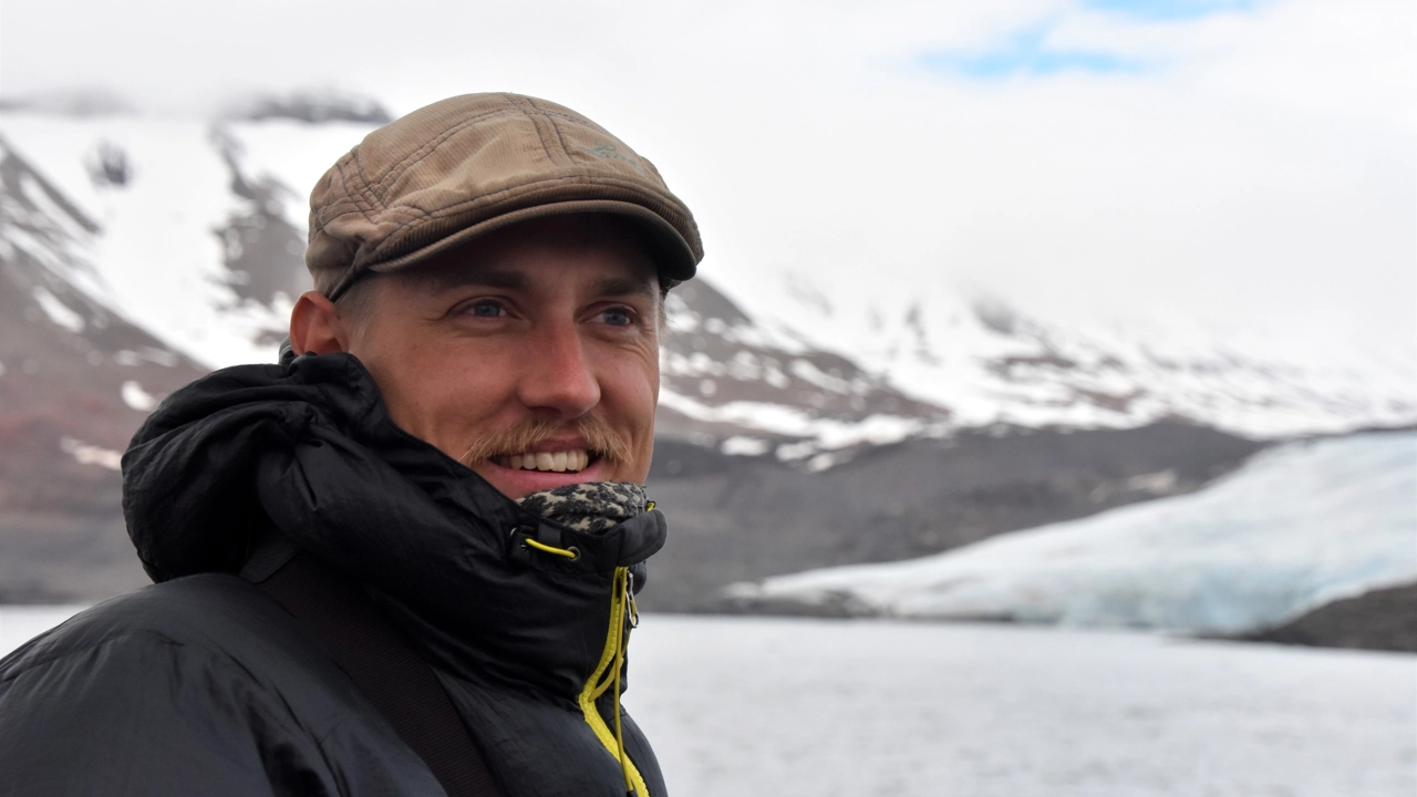 Photo of Viktor Gydemo during an excursion on Svalbard, mountain and lake in the background