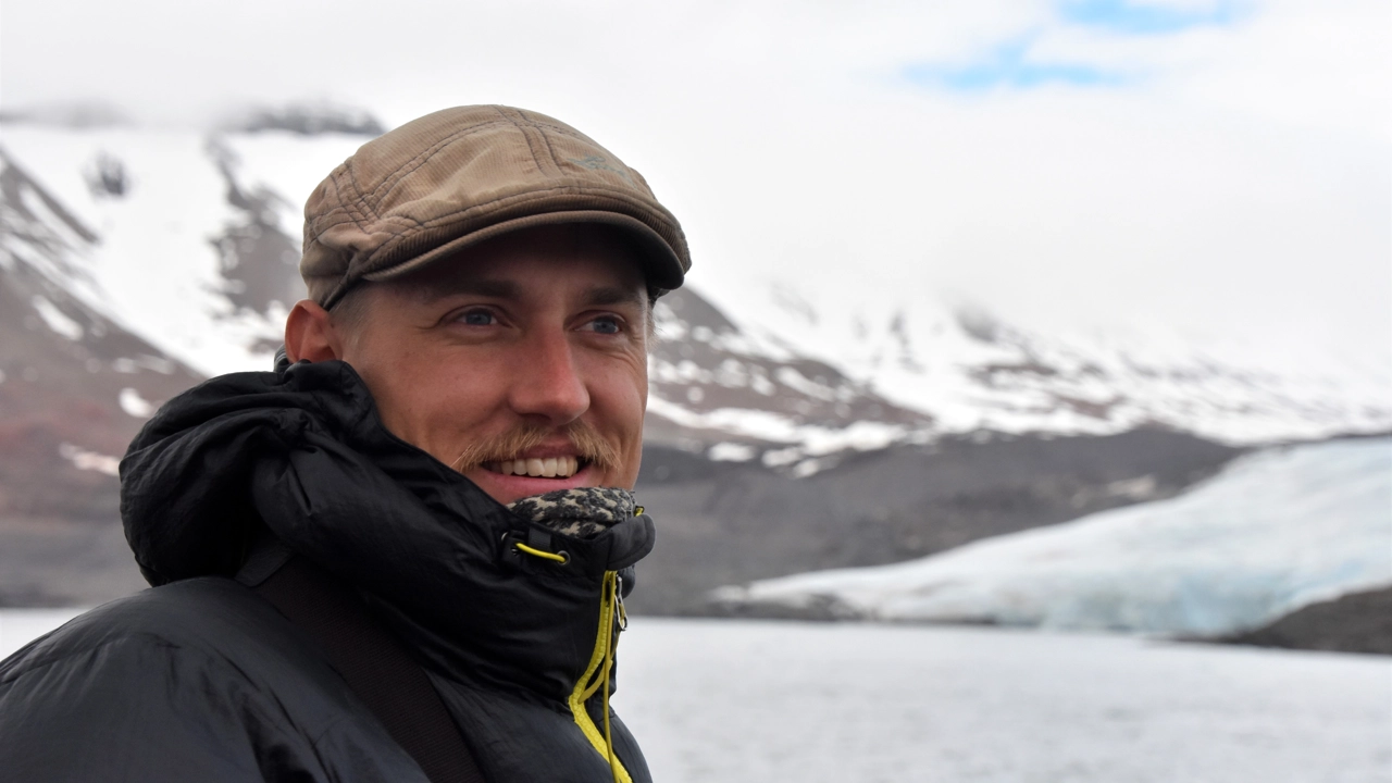 Portrait photo of Viktor Gydemo, snowy mountains and lake in the background
