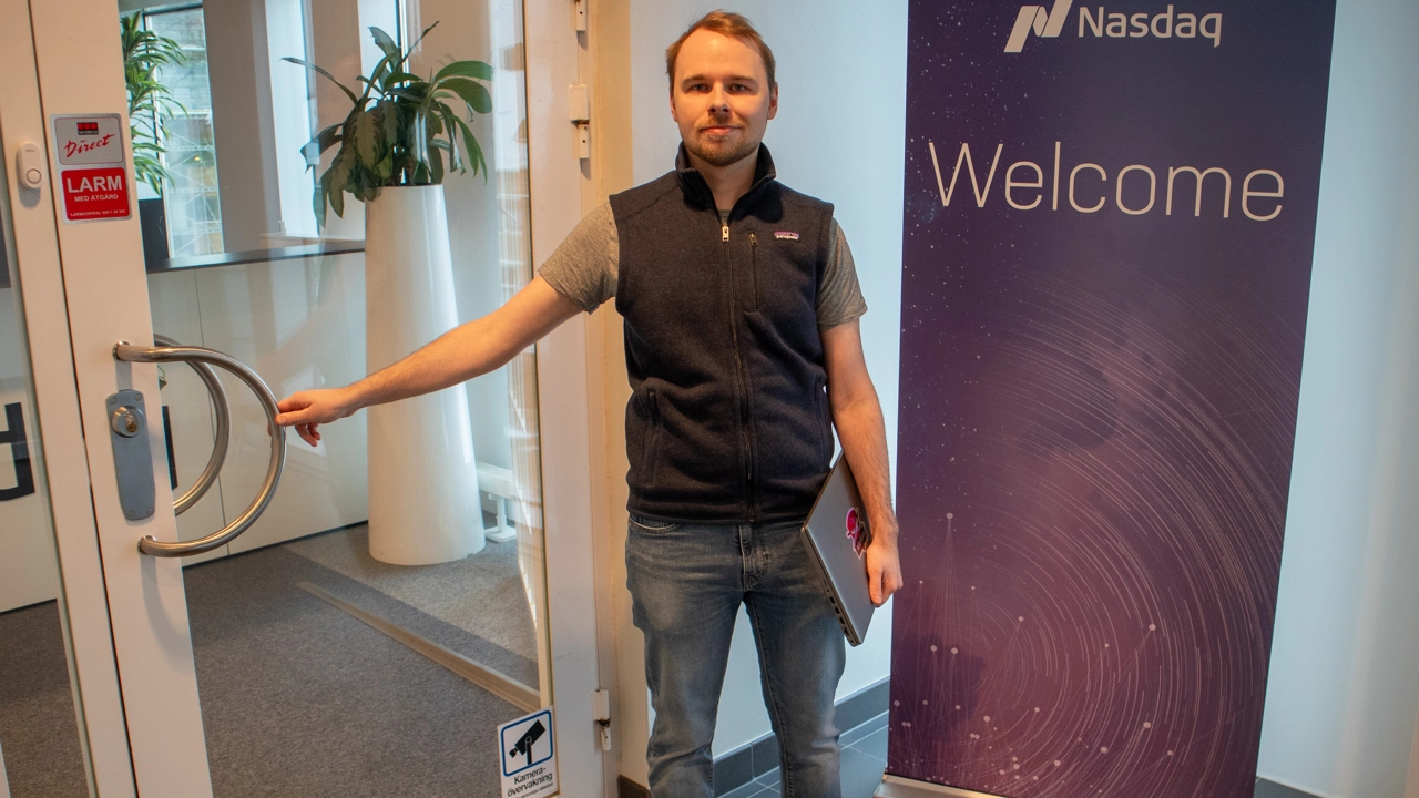 Bild på William Fransson vid entrén till Nasdaqs kontor i Umeå