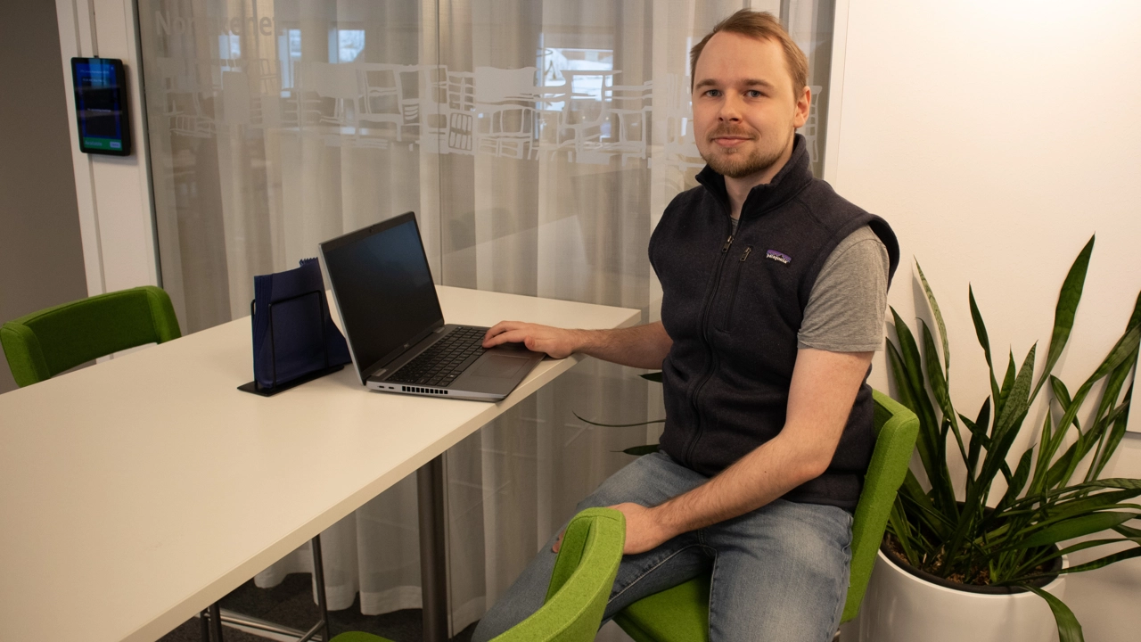 Bild på William Fransson sittande vid skrivbord med laptop framför sig