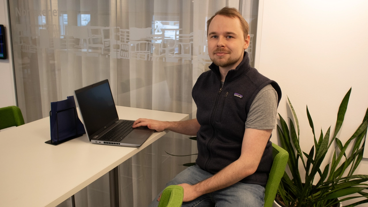 Bild på William Fransson sittande vid skrivbord med laptop framför sig