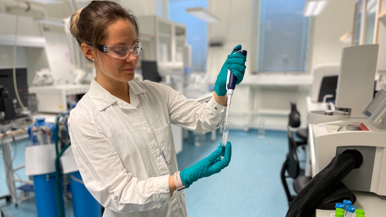 Bild på Zandra Gidlöf i vit labbrock hållande en pipett